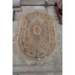 AN OVAL PEACH PATTERNED FRINGED RUG