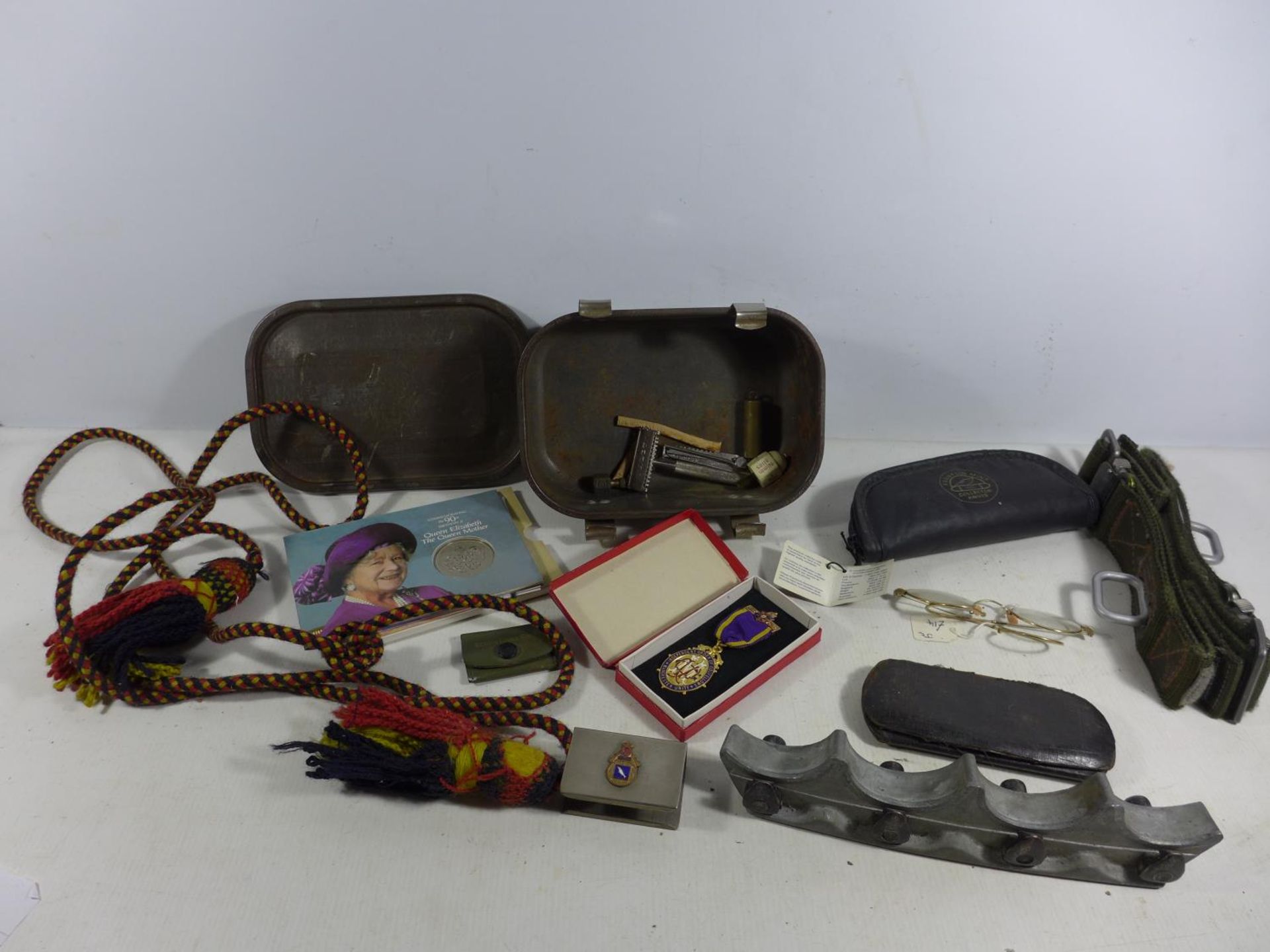 A METAL TIN AND CONTENTS, MILITARY BELT, QUEEN ELIZABETH £5, GLASSES ETC