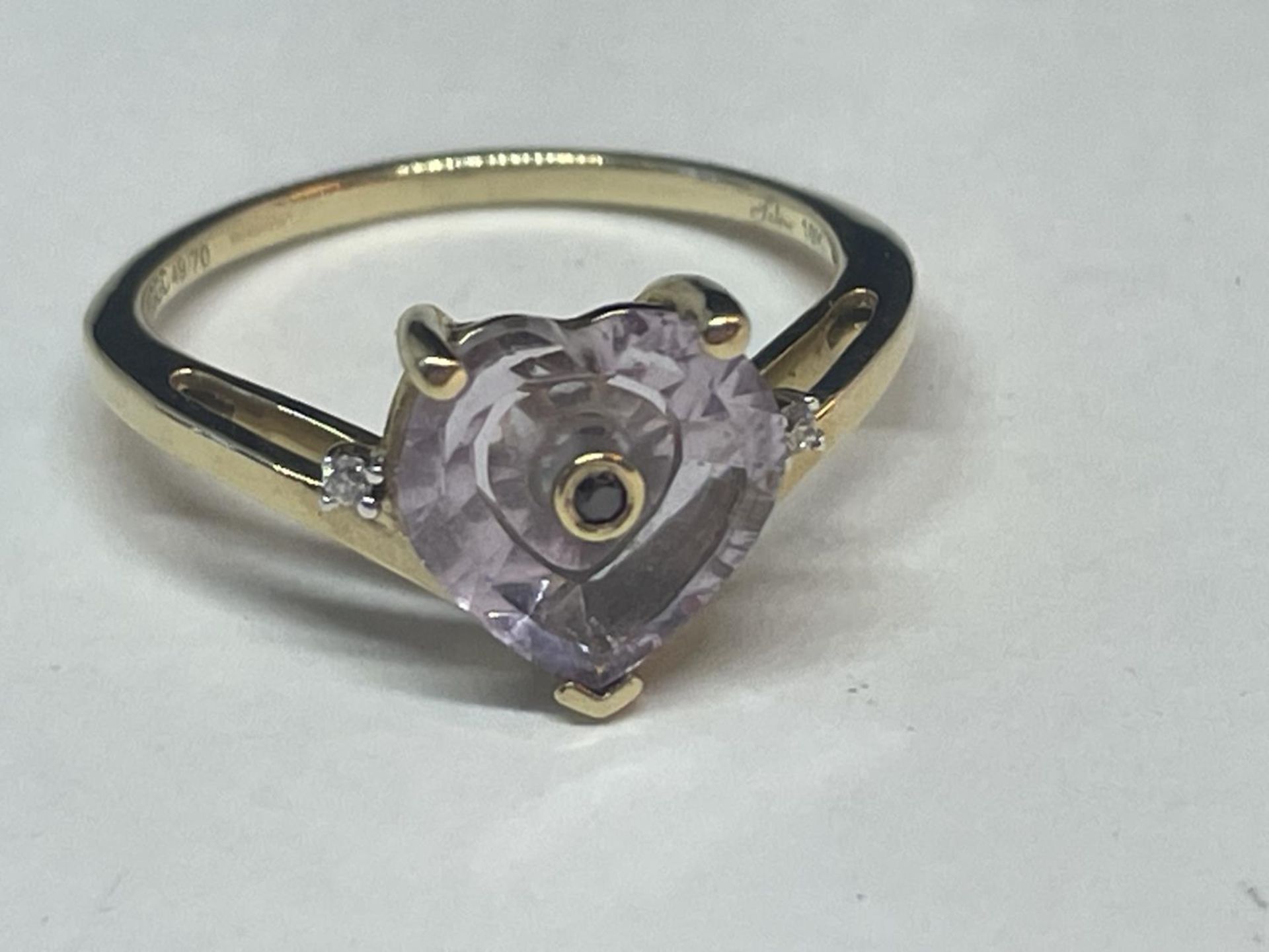 A 9 CARAT GOLD RING WITH A HEART SHAPED AMETHYST AND TWO DIAMONDS SIZE N/O