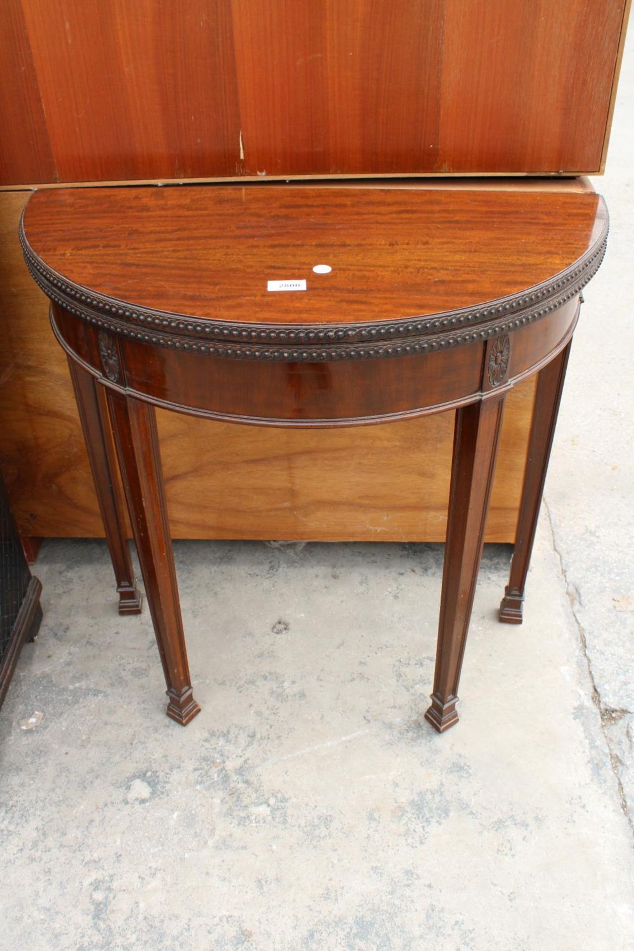 A 19TH CENTURY STYLE DEMI-LUNE GAMES TABLE, POSSIBLY BY WARING AND GILLOW, 28" WIDE