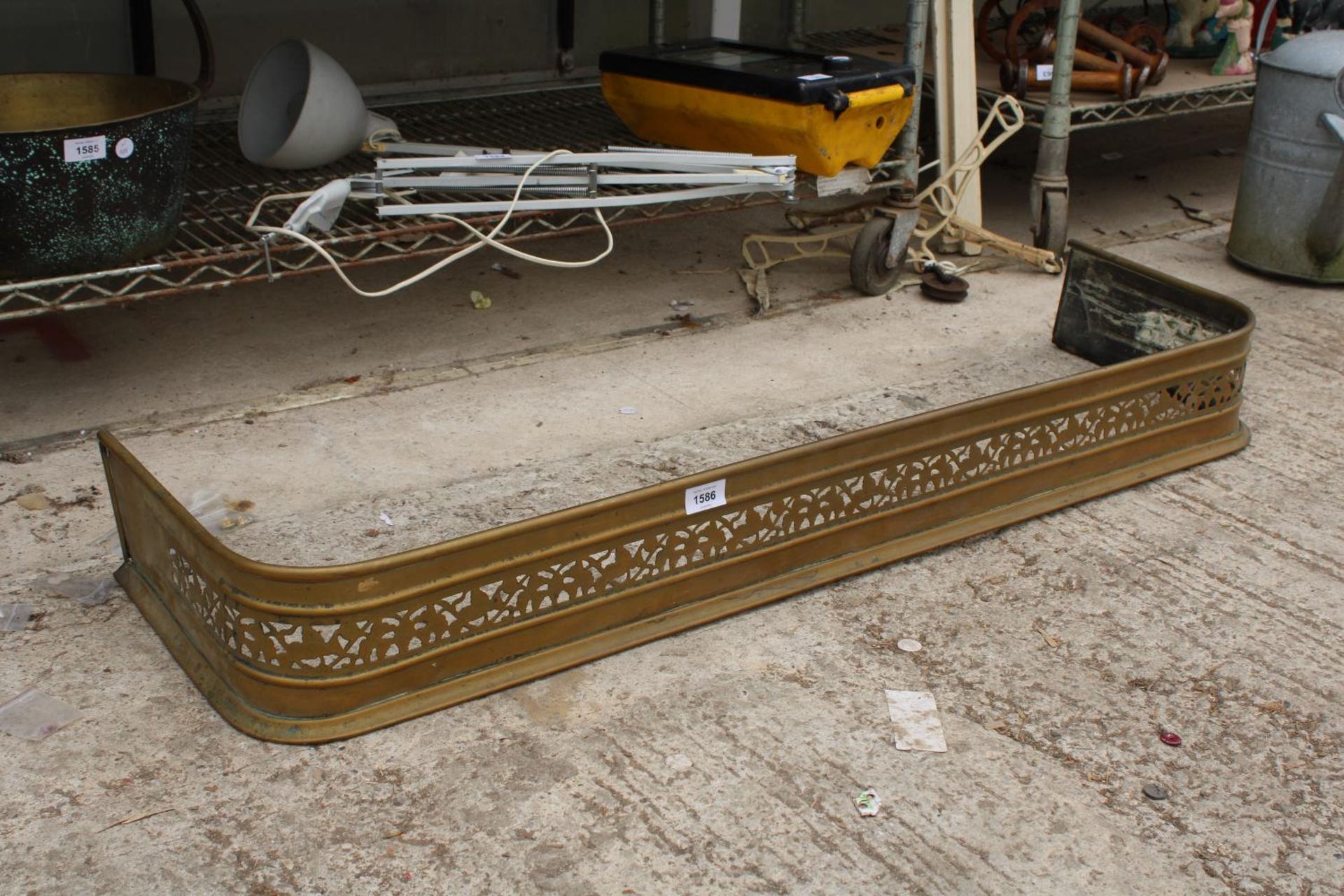 A VINTAGE AND DECORATIVE PIERCED BRASS FIRE FENDER