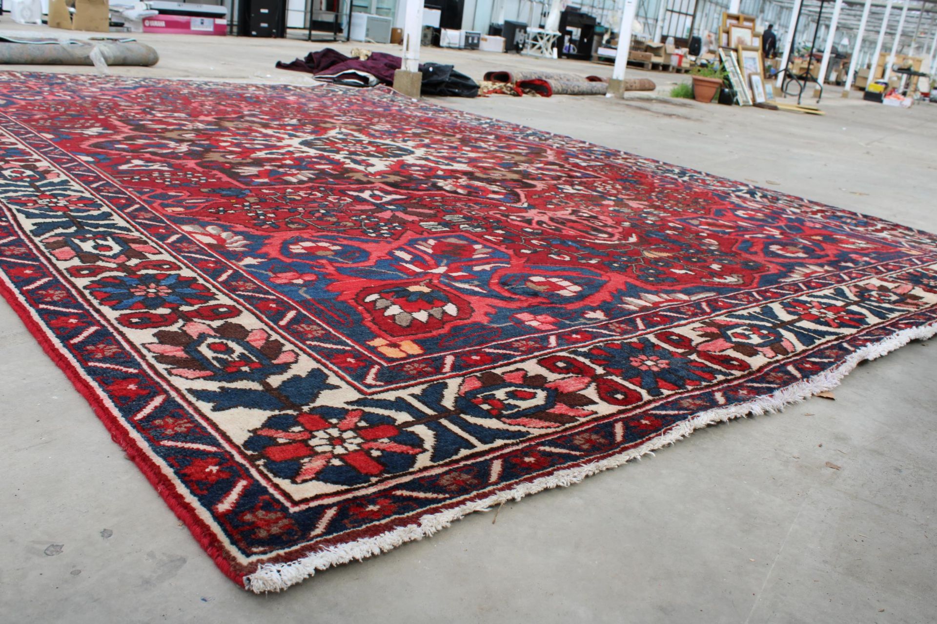 A LARGE RED PATTERNED FRINGED RUG - Image 5 of 5