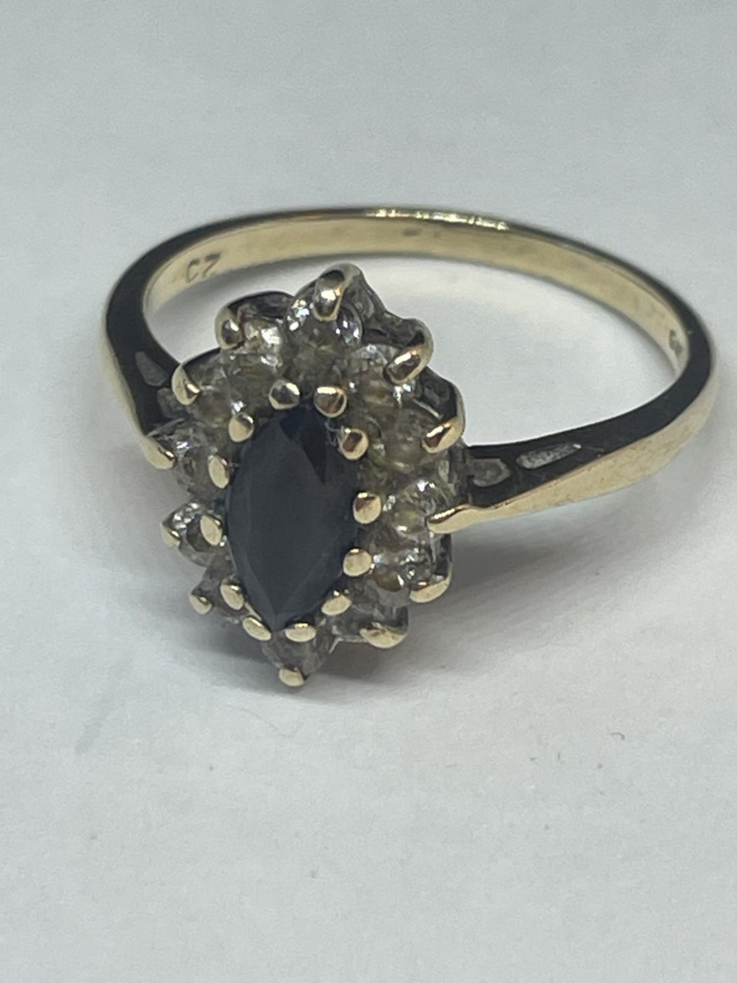 A 9 CARAT GOLD RING WITH CENTRE SAPPHIRE SURROUNDED BY CUBIC ZIRCONIAS SIZE N/O