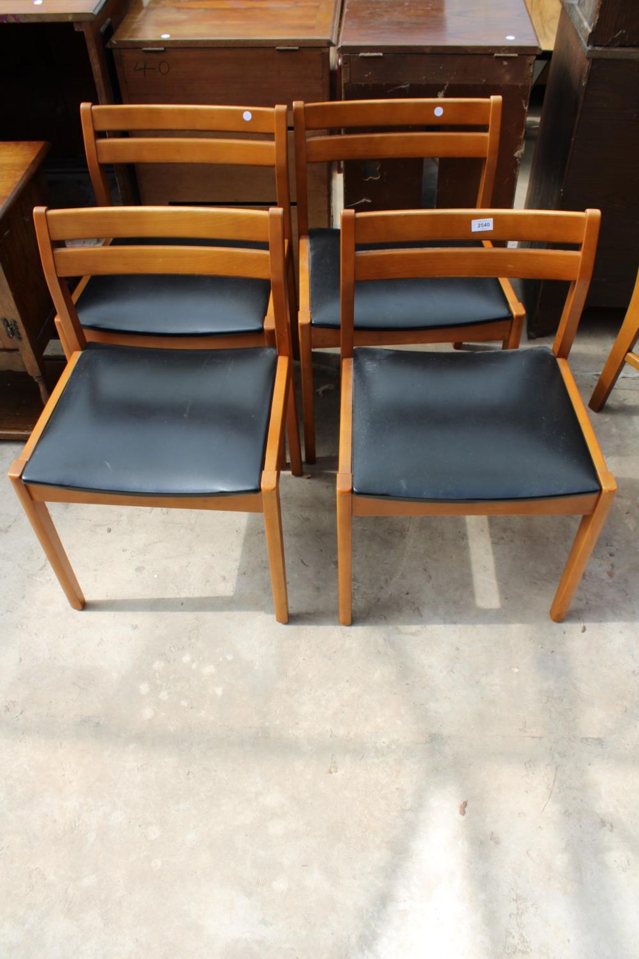 A SET OF 4 RETRO TEAK DINING CHAIRS WITH BLACK FAUX LEATHER SEATS