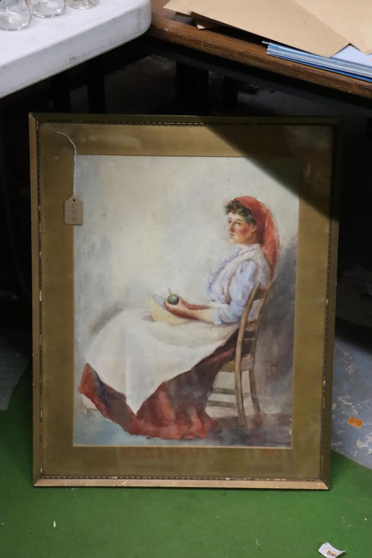 A GOLD FRAMED WATERCOLOUR OF A LADY PREPARING VEGETABLES