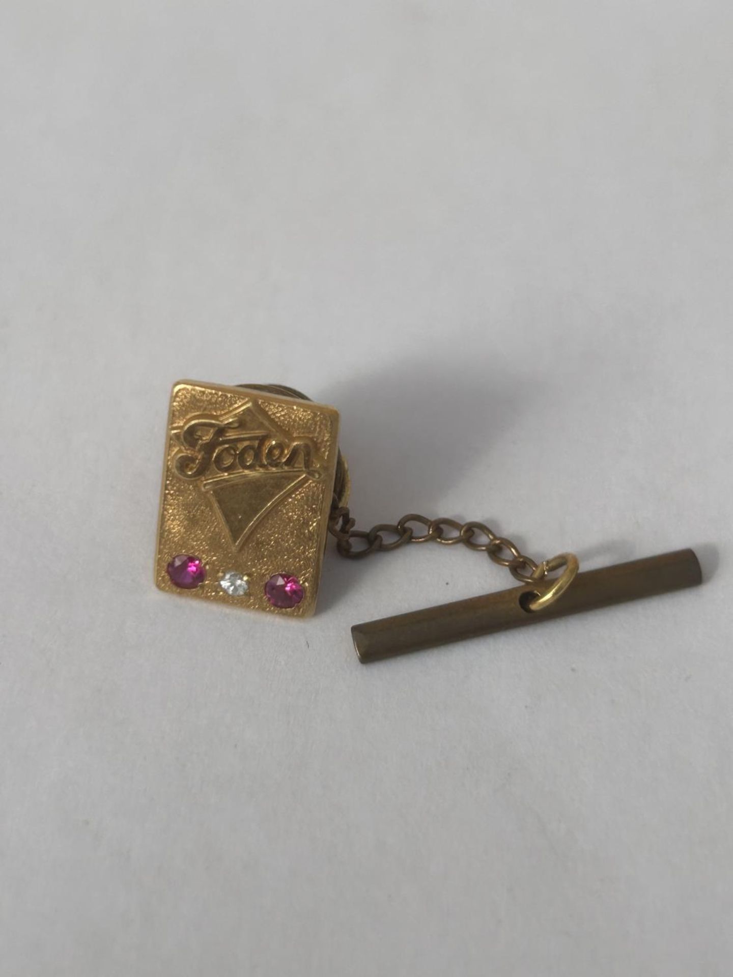 A HALLMARKED 9CT GOLD DIAMOND AND RUBY FODEN TRUCKS PIN BADGE GROSS WEIGHT 4.84 G