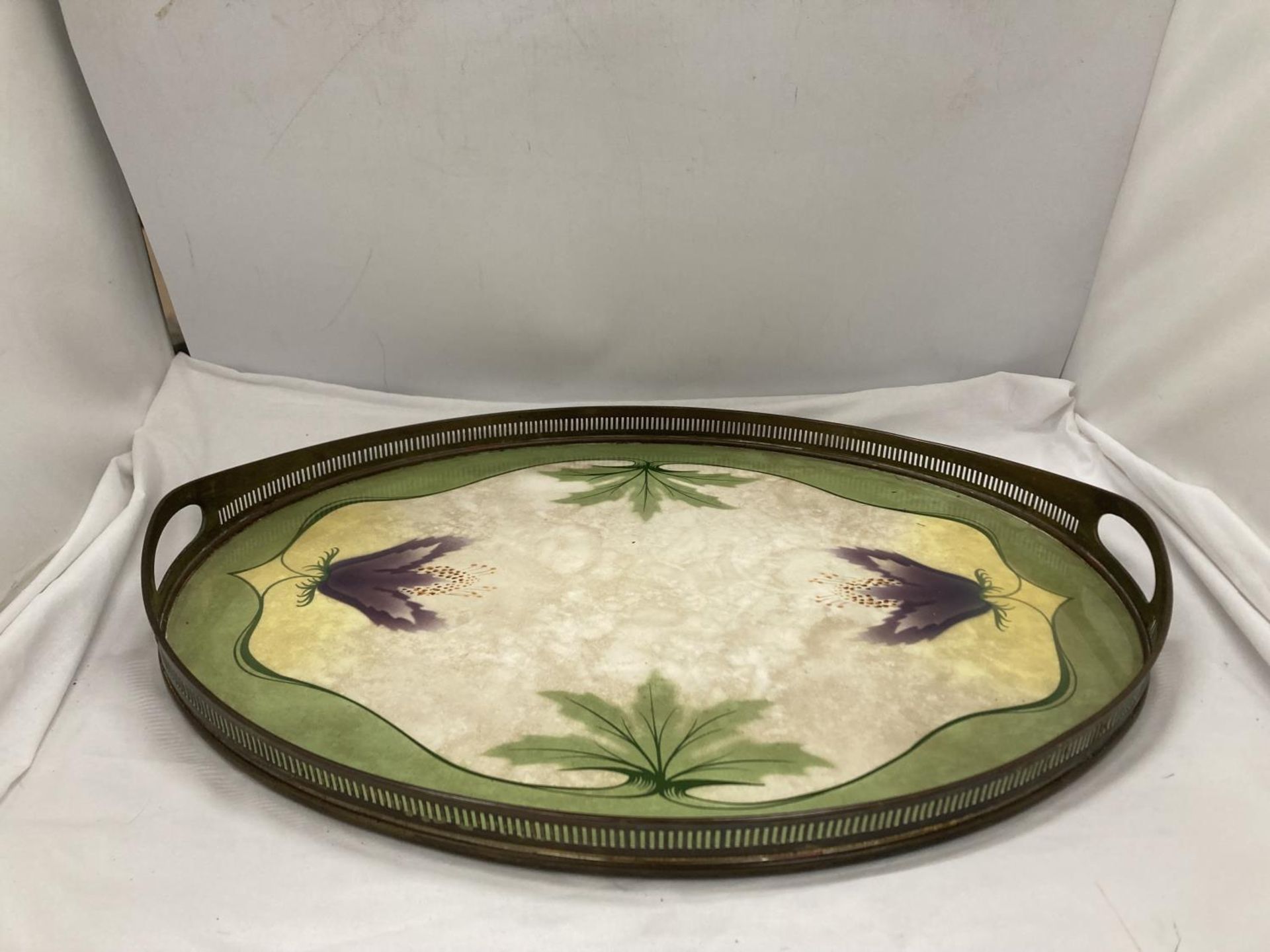 AN ART NOUVEAU STYLE BRASS AND CERAMIC TRAY WITH GALLERIED SIDES ADORNED WITH FLOWERS AND LEAVES