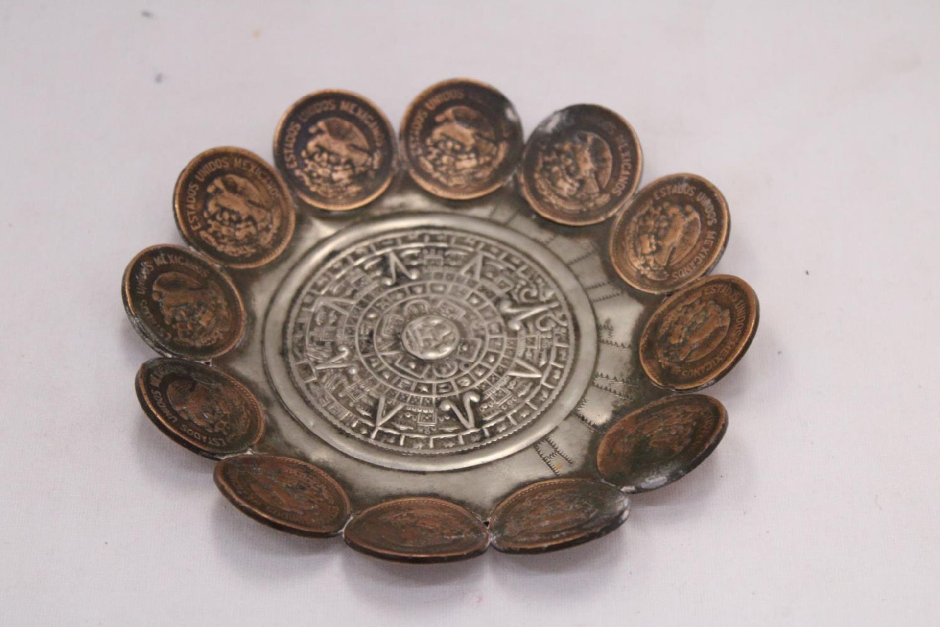 AN AZTEC PEWTER BOWL WITH 1940'S-1950'S CENTAVOS SURROUND, DIAMETER 13CM