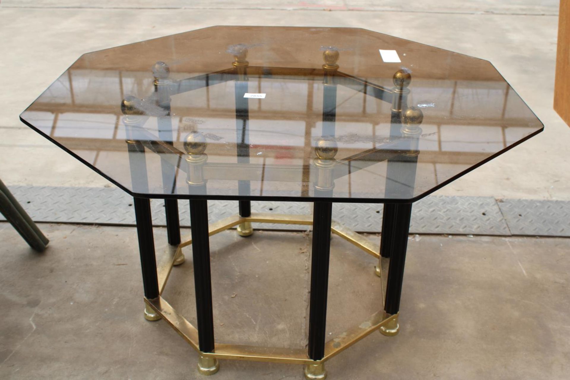 A RETRO OCTAGONAL SMOKED GLASS COFFEE TABLE ON BLACK AND BRASS EFFECT BASE - Image 2 of 2