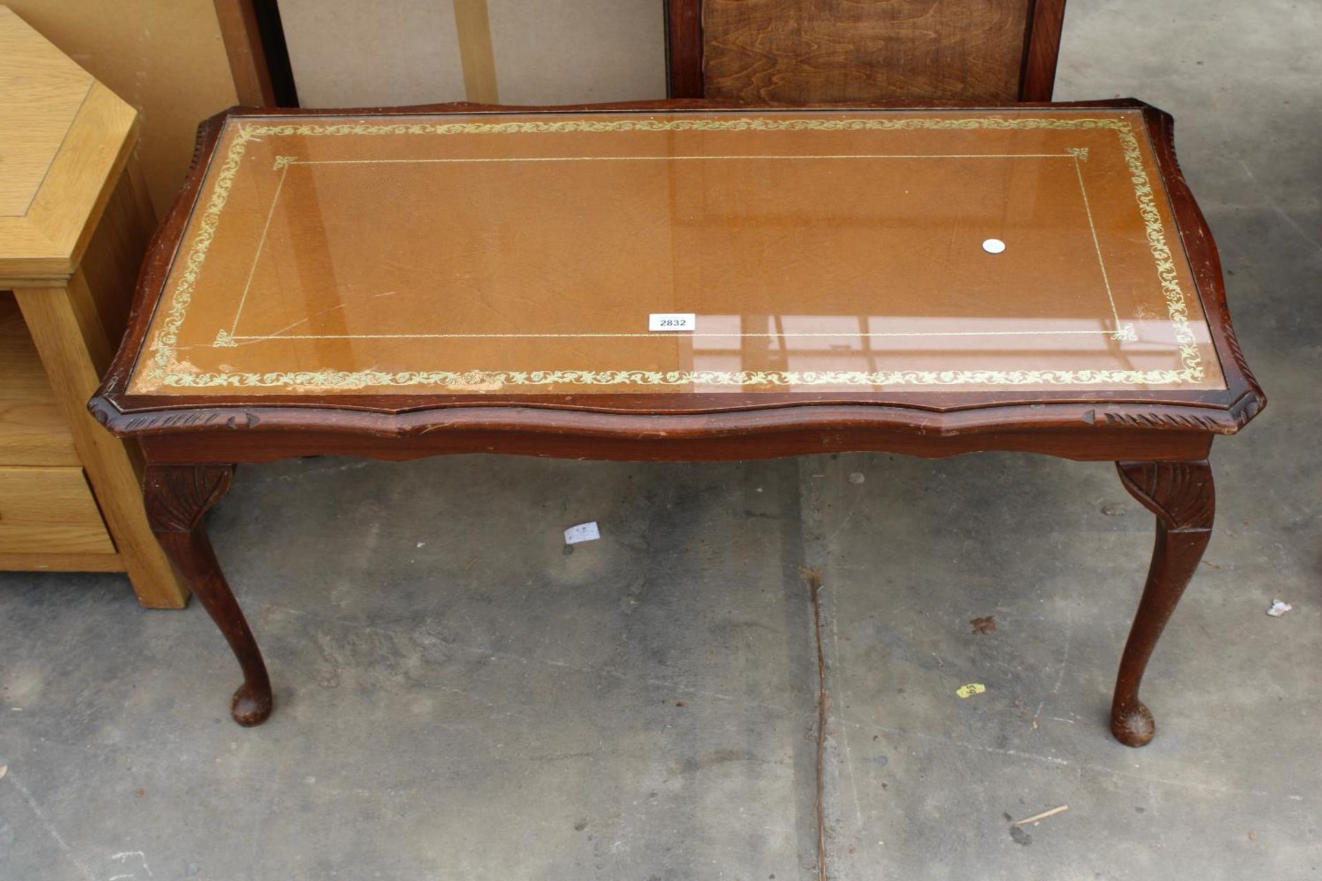 A MAHOGANY COFFEE TABLE WITH INSET LEATHER TOP ON CABRIOLE LEGS