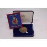A BOXED BRONZE MEDAL AND ACCOMPANYING PATCH