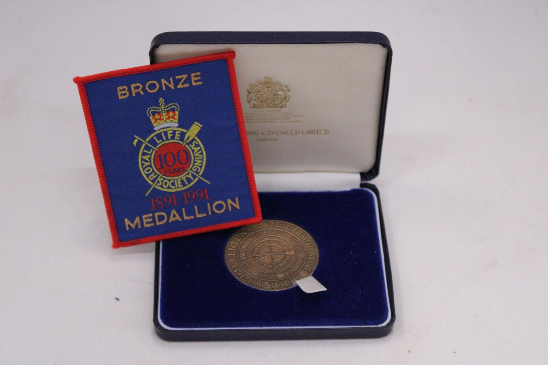 A BOXED BRONZE MEDAL AND ACCOMPANYING PATCH