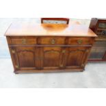 AN OAK GEORGE III STYLE DRESSER BASE, ENCLOSING 3 DRAWERS AND 3 PANELLED CUPBOARDS, WITH 'H' BRASS