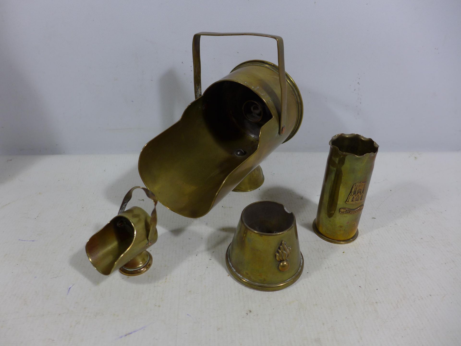 FOUR BRASS WORLD WAR I TRENCH ART ITEMS, TO INCLUDE TWO HELMET SHAPED MINIATURE COAL BUCKETS