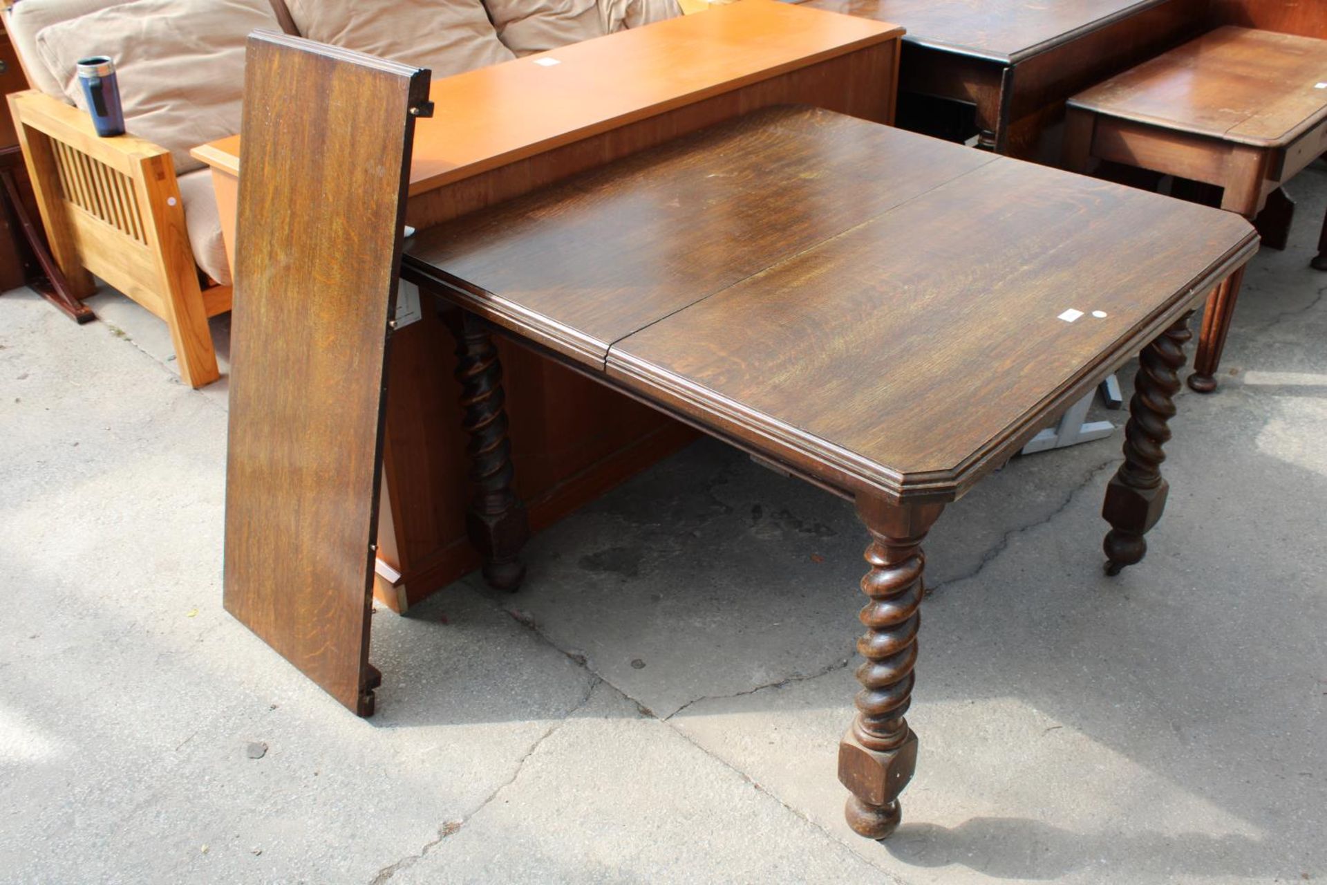 AN EARLY 20TH CENTURY OAK EXTENDING DINING TABLE ON BARLEY-TWIST LEGS WITH CANTED CORNERS, 41"