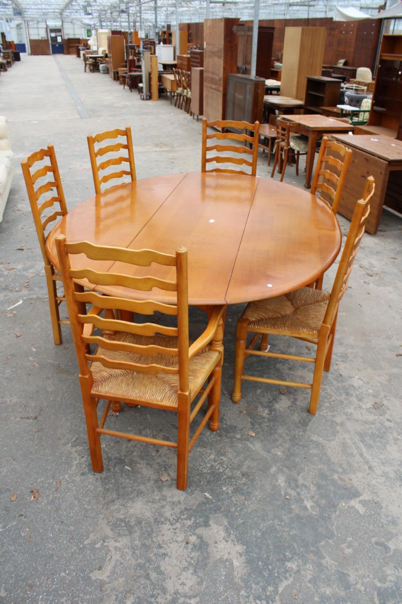 A GEORGIAN STYLE OVAL OAK WAKES TABLE, 77" X 59" OPENED AND SIX LADDER BACK DINING CHAIRS WITH