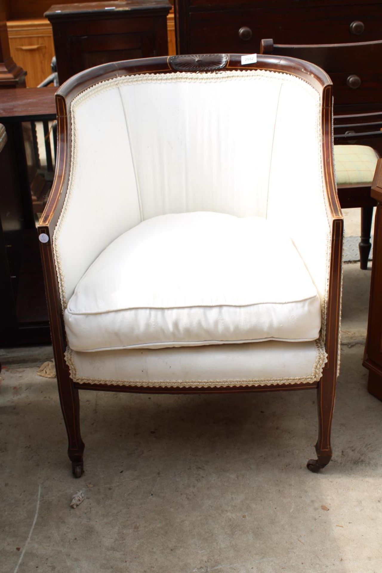 AN EDWARDIAN MAHOGANY AND INLAID UPHOLSTERED LOUNGE CHAIR