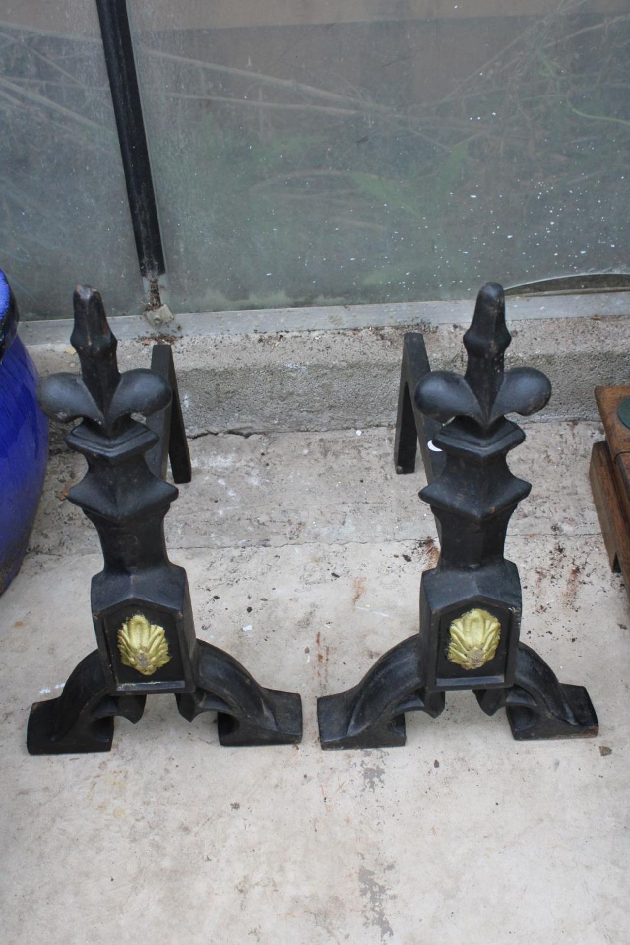 A PAIR OF DECORATIVE CAST IRON FIRE DOGS
