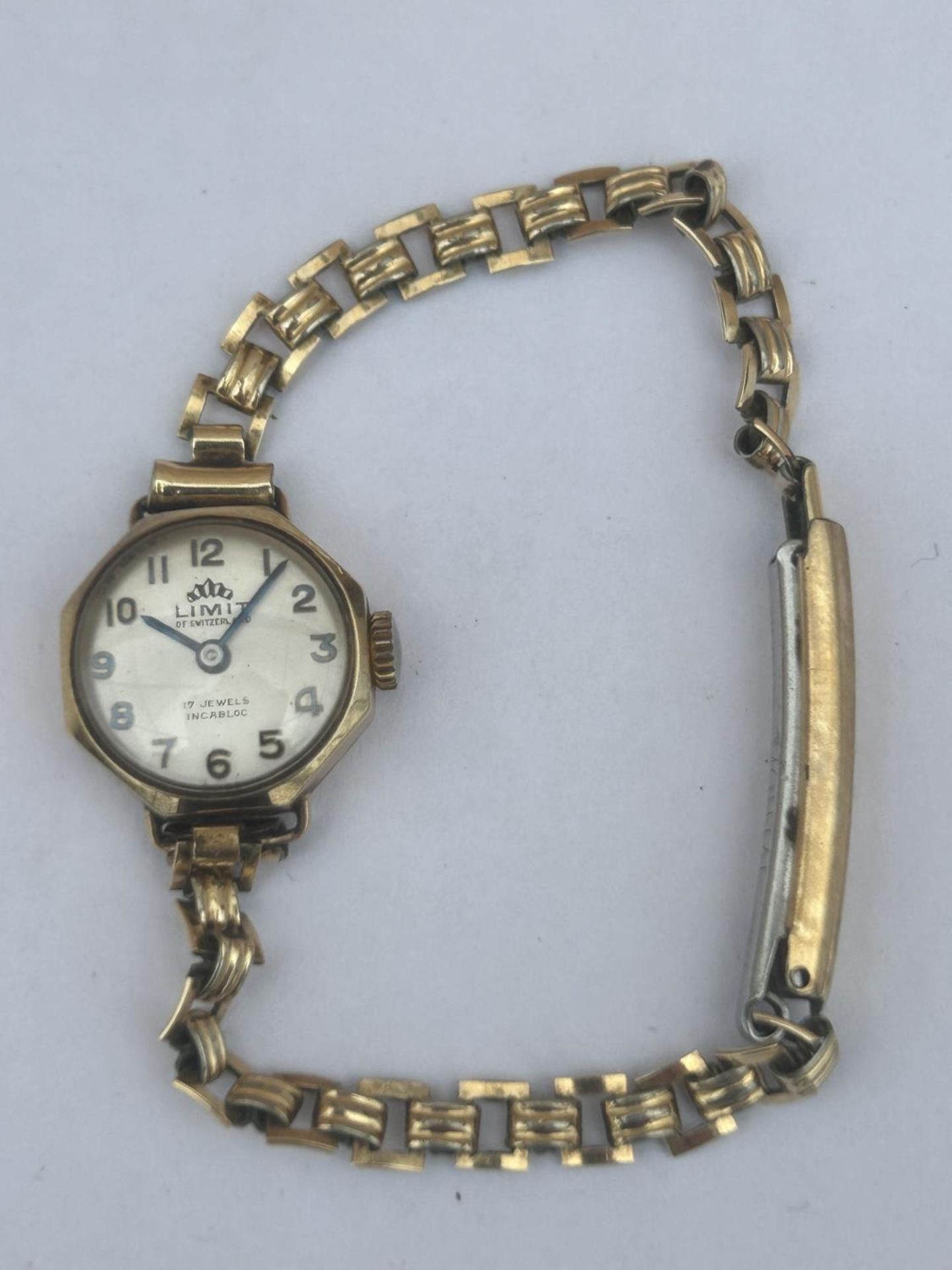 A 9CT GOLD CASED LADIES LIMIT OF SWITZERLAND WATCH, WITH 17 JEWEL MOVEMENT