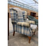 A MODERN CHECK WINGED FIRESIDE CHAIR ON FRONT CABRIOLE LEGS