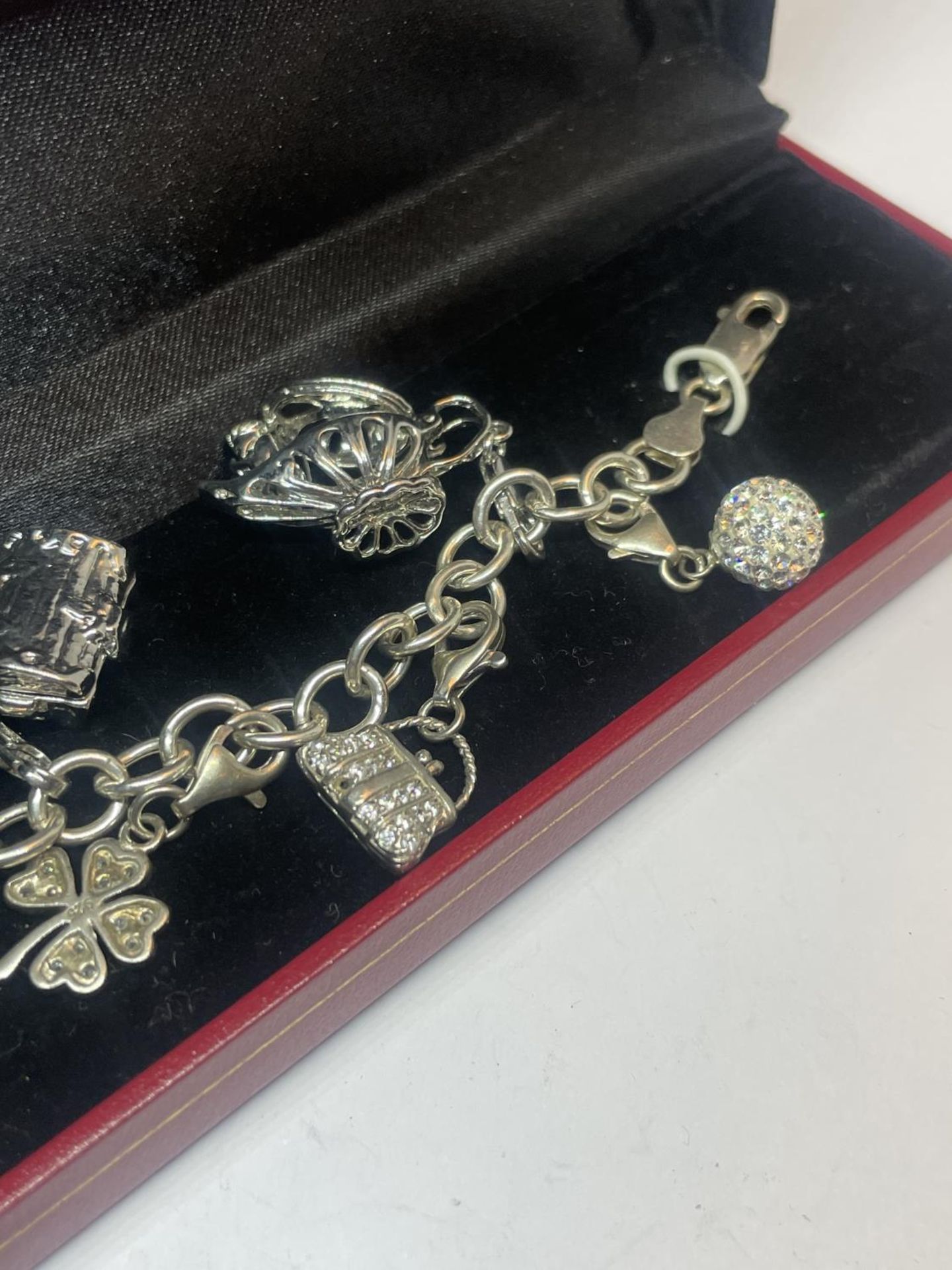 A SILVER CHARM BRACELET WITH NINE CHARMS IN A PRESENTATION BOX - Image 4 of 4