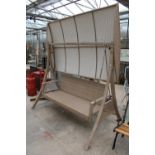 A LARGE THREE SEATER RATTAN SWING SEAT WITH CANOPY