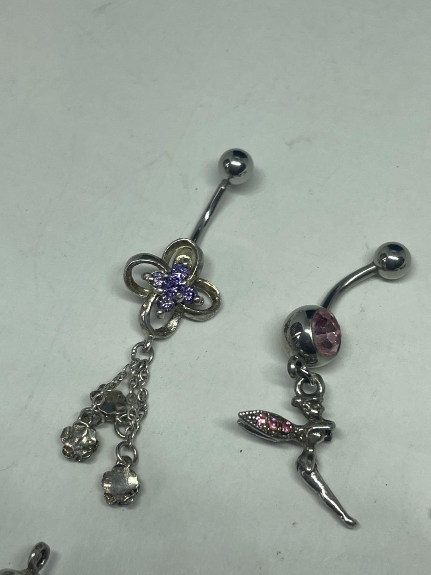 SEVEN SILVER ITEMS TO INCLUDE TWO BELLY BARS AND FIVE CHARMS - Image 2 of 3