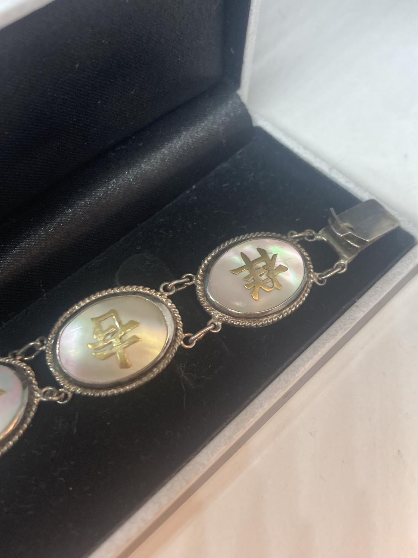 AN ORIENTAL SILVER AND MOTHER OF PEARL CHARACTER LINK BRACELET IN A PRESENTATION BOX - Image 7 of 10