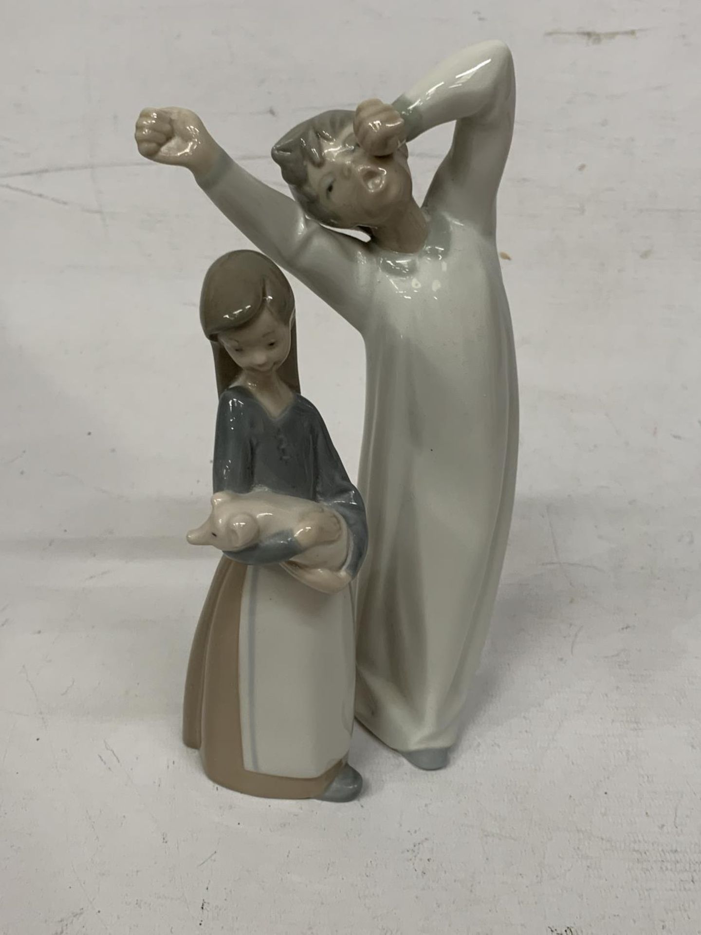 TWO LLADRO FIGURES - BOY YAWNING IN A NIGHTGOWN AND A GIRL HOLDING A PIG