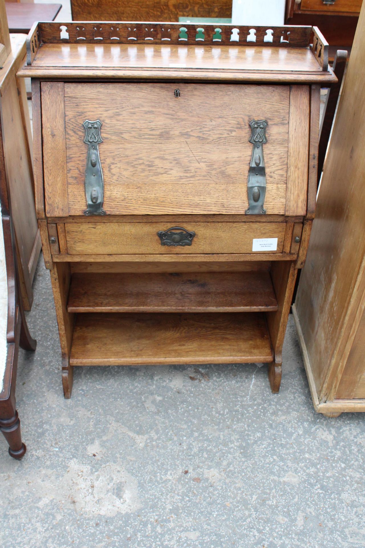 AN OAK ARTS AND CRAFTS BUREAU WITH GALLERY BACK AND OPEN BASE, 30" WIDE