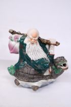 A CHINESE PORCELAIN WISE MAN RIDING A DRAGON TURTLE