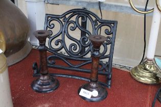 A CAST IRON BOOK STAND AND A PAIR OF VINTAGE WOODEN CANDLESTICKS