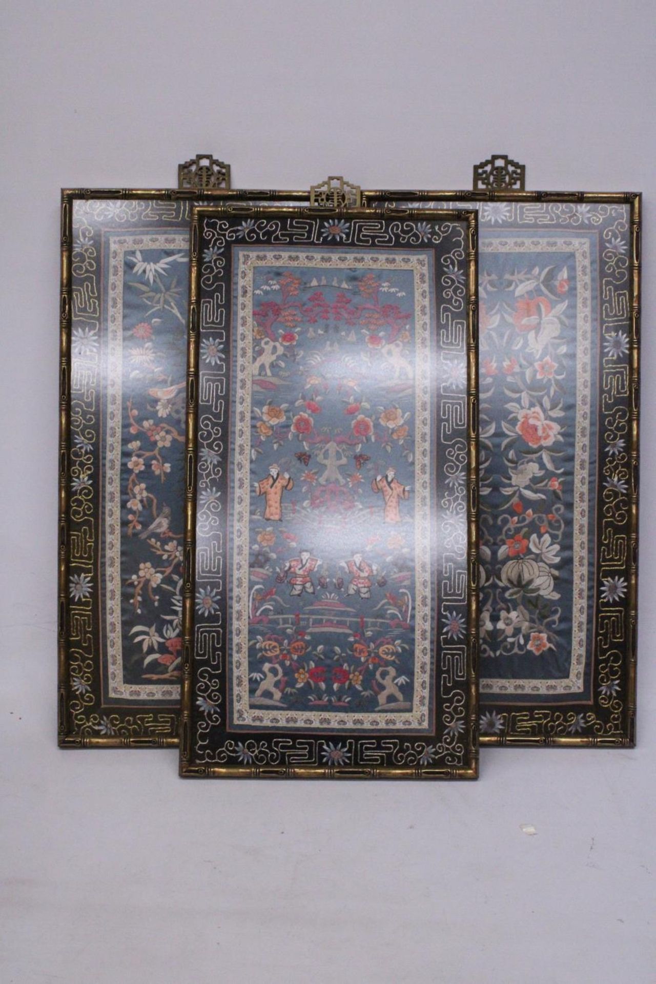 THREE CHINESE SILK EMBROIDERIES DEPICTING A LANDSCAPE SCENE, BIRDS AND FLORALS IN BAMBOO FRAMES