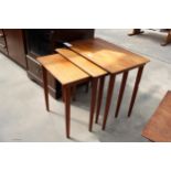 A RETRO TEAK NEST OF THREE TABLES ON TAPERING LEGS