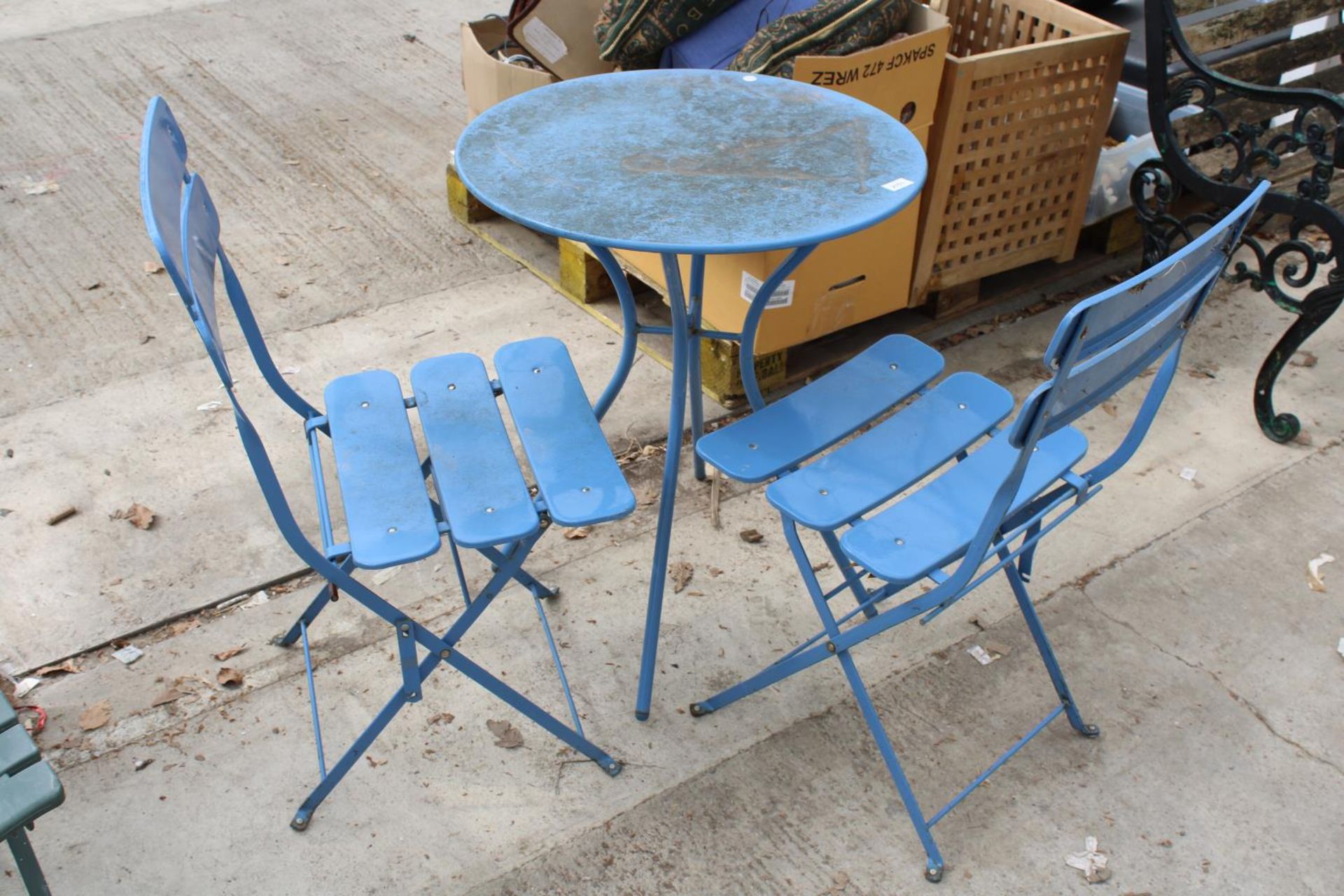 A BLUE METAL BISTRO TABLE AND TWO MATCHING FOLDING CHAIRS