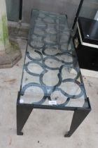 A VINTAGE STYLE METAL COFFEE TABLE WITH GLASS TOP AND FORMED FROM HORSE SHOES