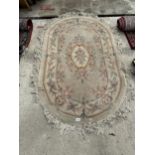 AN OVAL PEACH PATTERNED FRINGED RUG