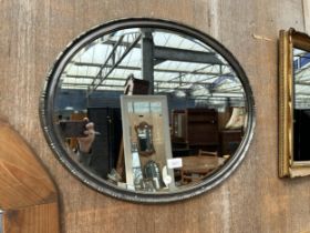 AN OVAL GILT FRAMED BEVEL EDGE MIRROR