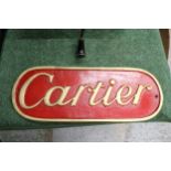 AN ALUMINIUM 'CARTIER' SIGN, 40CM X 15CM