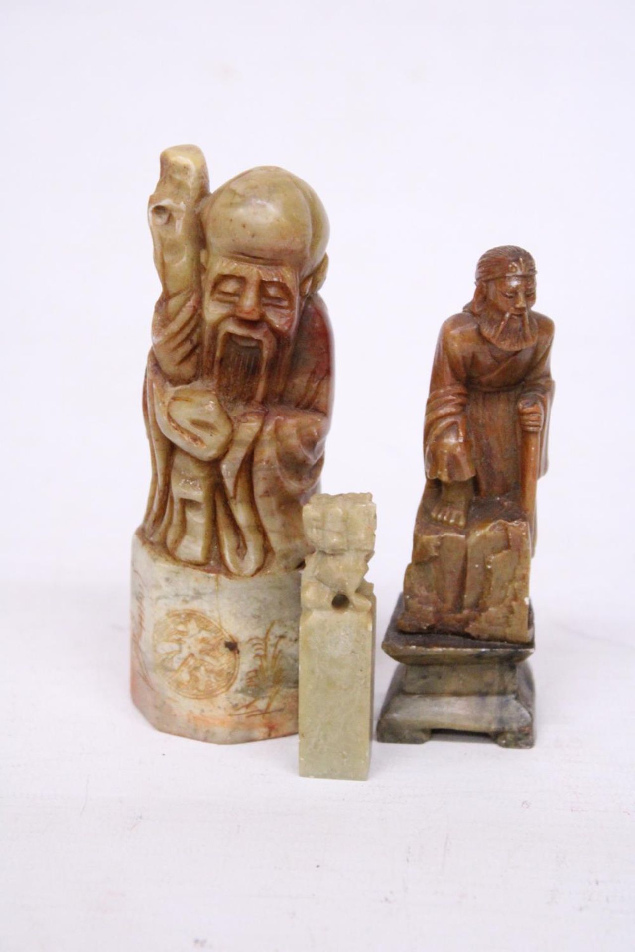 A CHINESE SHOU LAO TAO IMMORTAL CARVED SOAPSTONE SEAL TOGETHER WITH TWO FURTHER CARVINGS