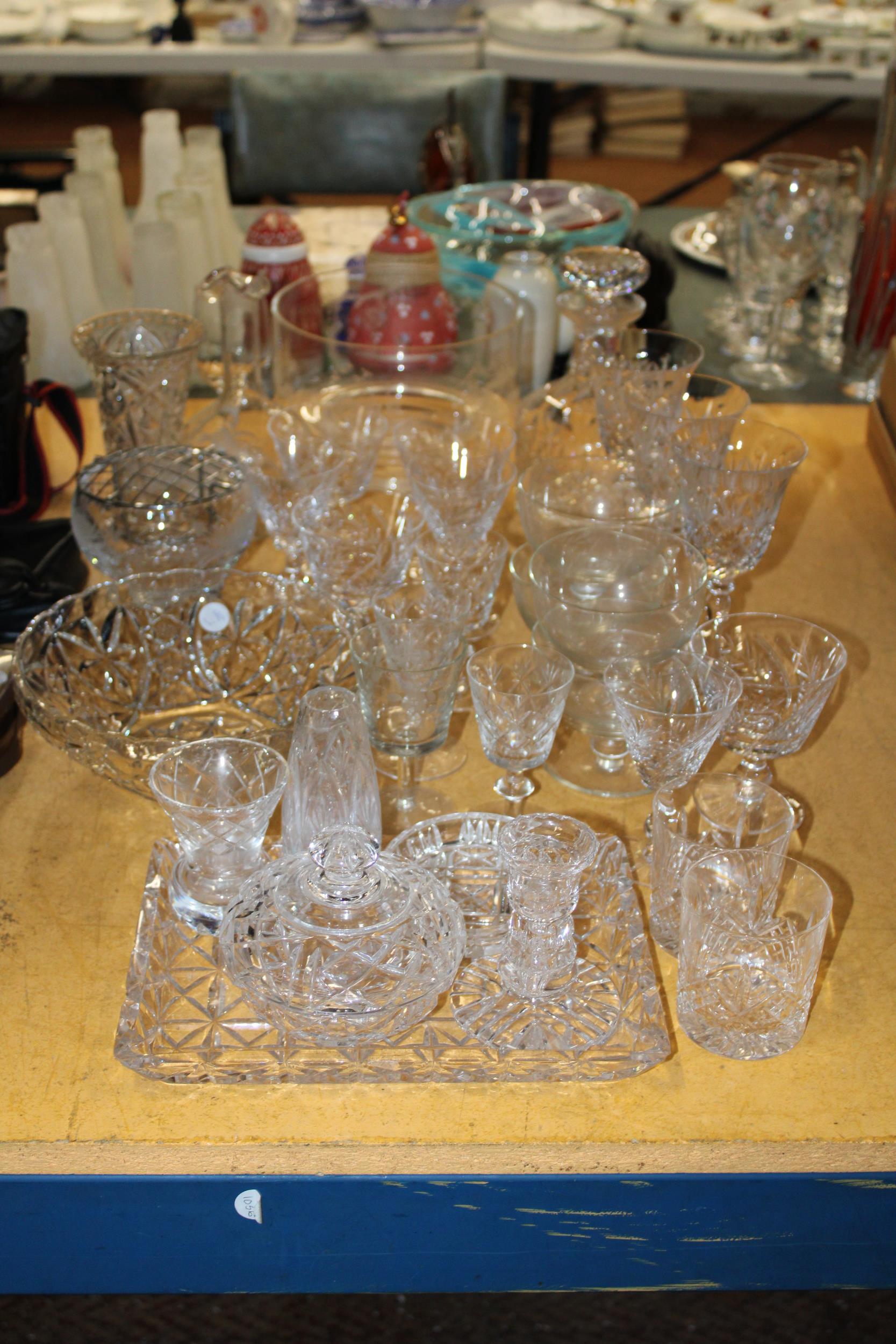 A LARGE QUANTITY OF GLASSWARE TO INCLUDE BOWLS, DECANTERS, A DRESSING TABLE SET, WINE GLASSES,