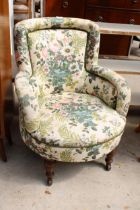 A LOW EDWARDIAN FLORAL UPHOLSTERED TUB CHAIR