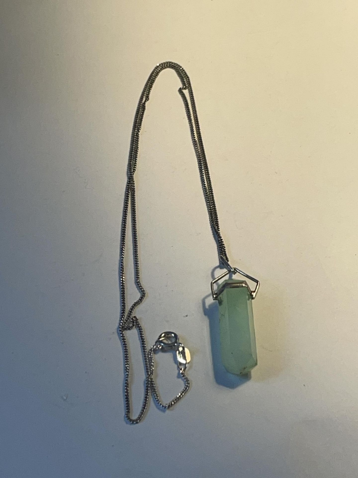 A JADE CRYSTAL PENDANT ON A 925 SILVER CHAIN