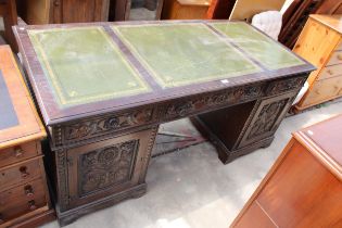 AN OAK JAYCEE TWIN-PEDESTAL DESK, TWO CARVED CUPBOARDS AND THREE DRAWERS WITH INSET LEATHER TOP, 68"