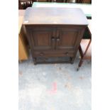 A JACOBEAN STYLE ELM TWO DOOR SIDE CABINET WITH SINGLE DRAWER, 31" WIDE