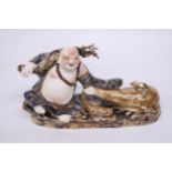 A CHINESE PORCELAIN BUDDHA PULLING A SACK WITH RATS