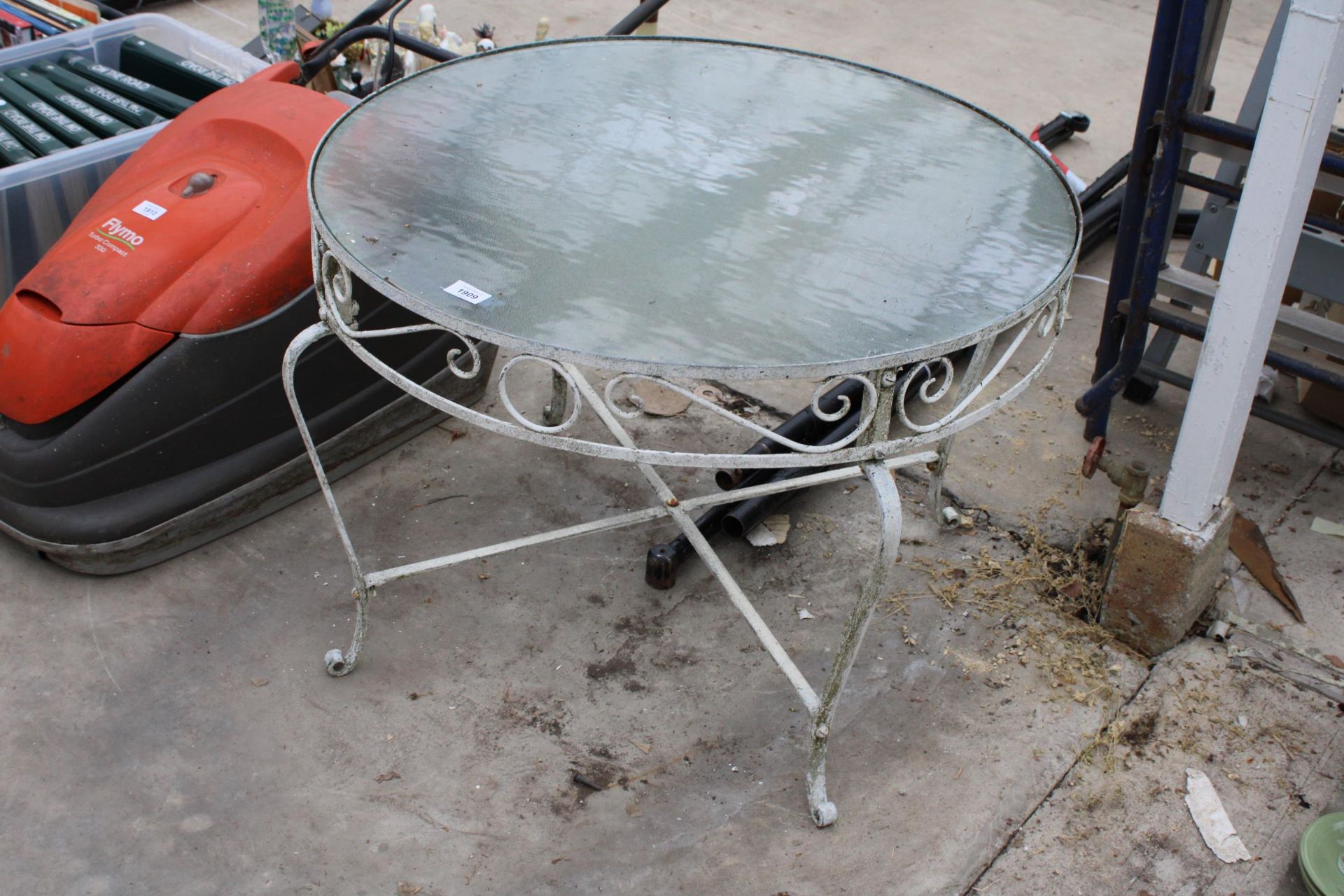 A GLASS TOPPED METAL FRAME GARDEN COFFEE TABLE