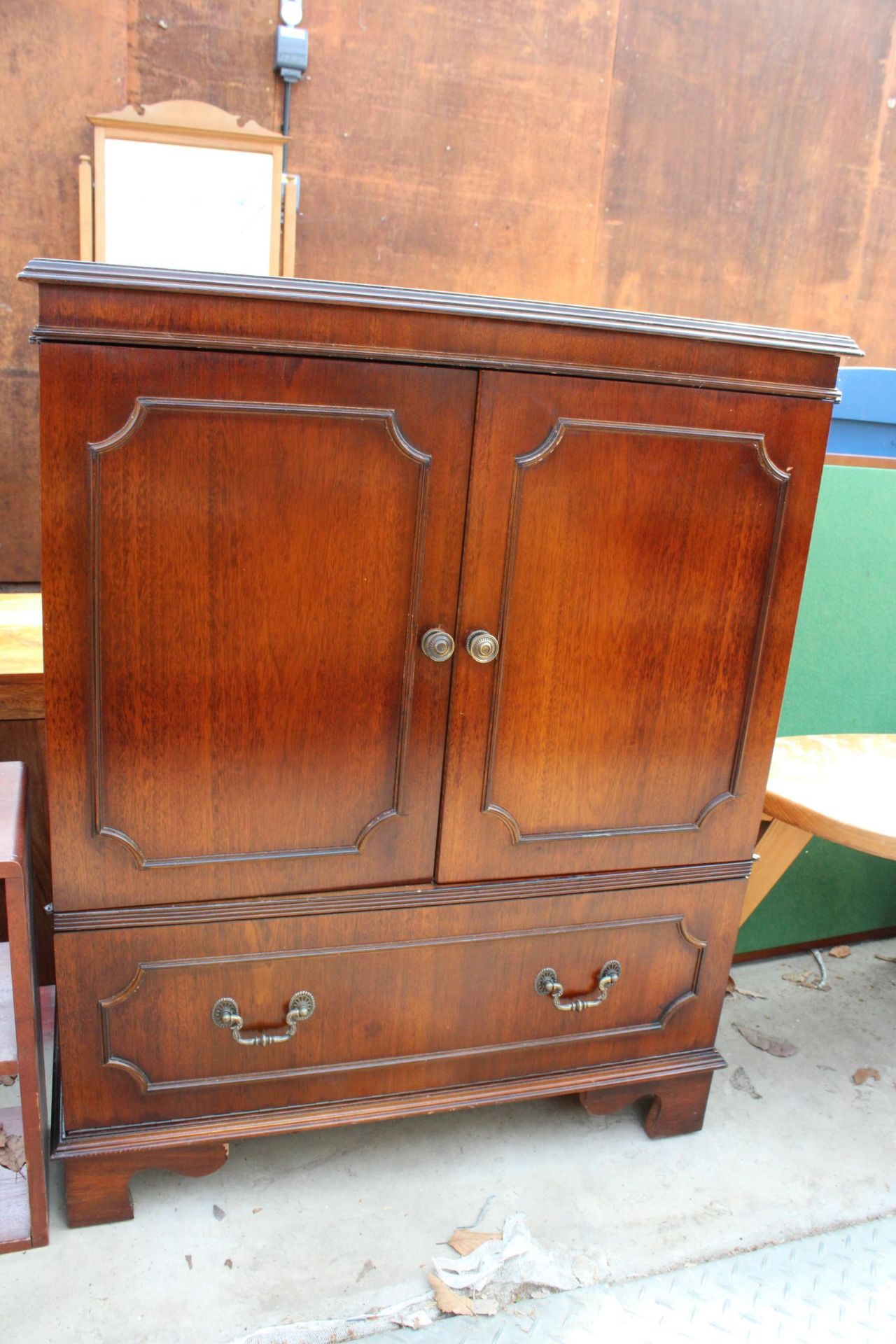 A MAHOGANY TWO DOOR T.V. CABINET