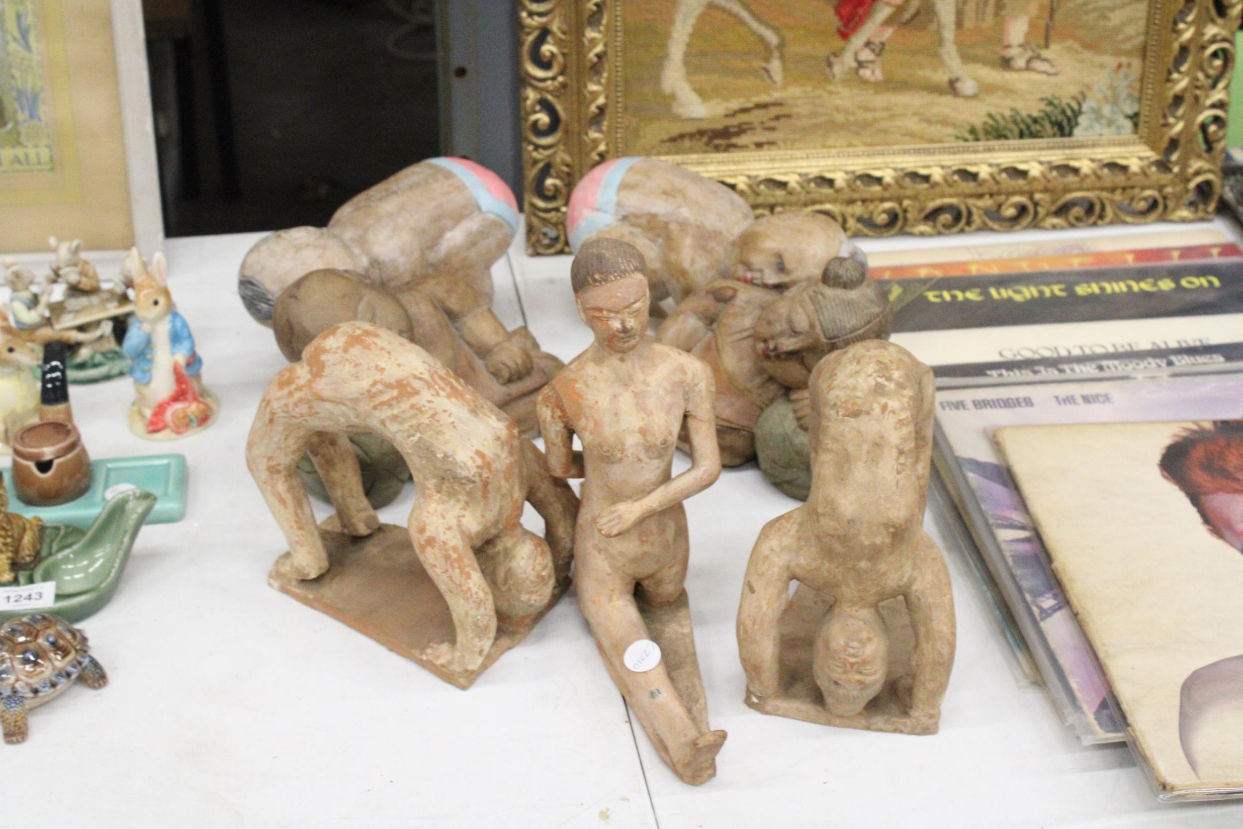 THREE LARGE CLAY MODELS OF GYMNASTS, PLUS FOUR WOODEN BABY BUDDAHS