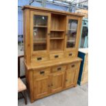 A OAK TWO DOOR BOOKCASE ON BASE, ENCLOSING SIX DRAWERS AND THREE CUPBOARDS, 55" WIDE